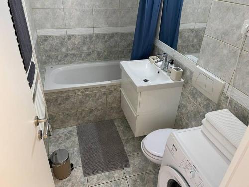 uma casa de banho com um lavatório, um WC e uma banheira em Spacious Apartment near Train Station em Ljubljana