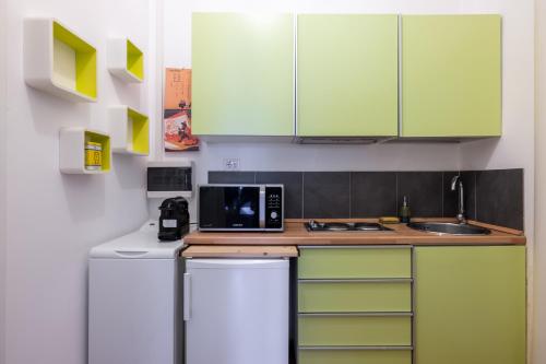 a kitchen with green cabinets and a microwave at Charming suite with view in the heart of Rome in Rome