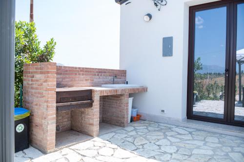 a brick fireplace in a patio with a window at Villa Marica in Partinico