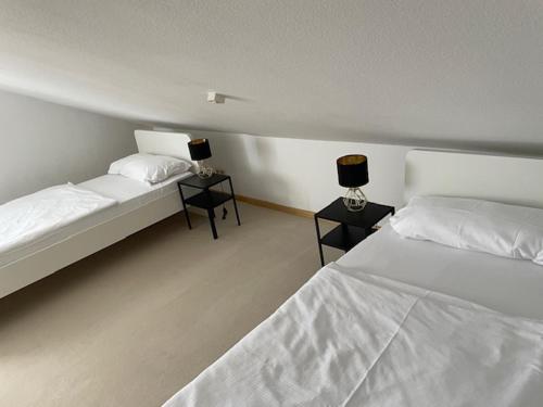 a bedroom with two beds and two lamps on tables at Dell Ferienwohnung in Offenburg