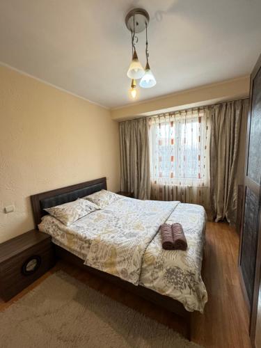 una camera da letto con un letto e una finestra di Квартира 5 в центре города a Shymkent