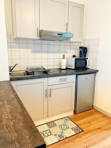 une cuisine avec un évier et un micro-ondes dans l'établissement STUDIO COSY Gare & centre-ville, à Saumur