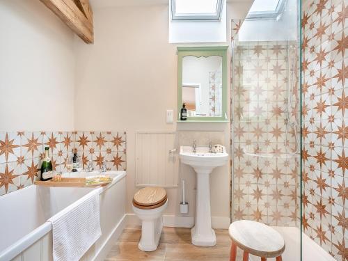 y baño con aseo, lavabo y ducha. en The Woodshed en Lower Boddington