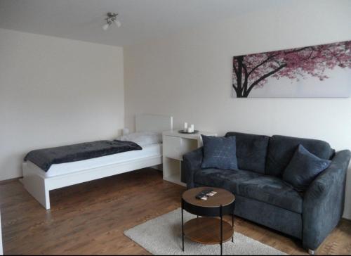 ein Wohnzimmer mit einem Sofa und einem Bett in der Unterkunft Kleines Appartement Gut und Preiswert in Stuttgart