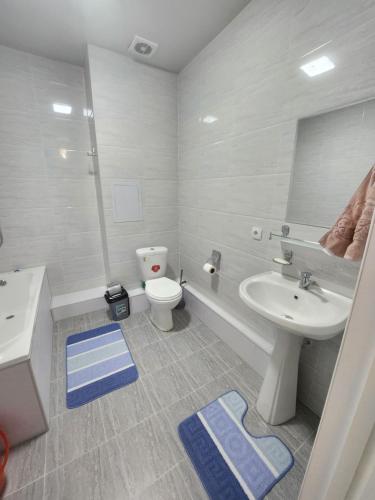 a white bathroom with a sink and a toilet at Hilmar in Tashkent