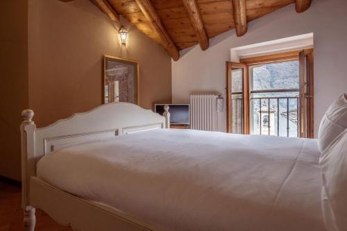 een slaapkamer met een wit bed en een raam bij Lake View 16 in Laglio