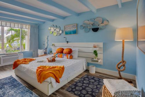 um quarto com uma cama grande e paredes azuis em DOLPHINS, BEACH step away, WIFI, FREE PARKING,POOLS, JACUZZI em Ruskin