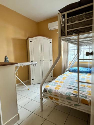 a bedroom with a bunk bed and a kitchen at Azure Escape in Soufrière