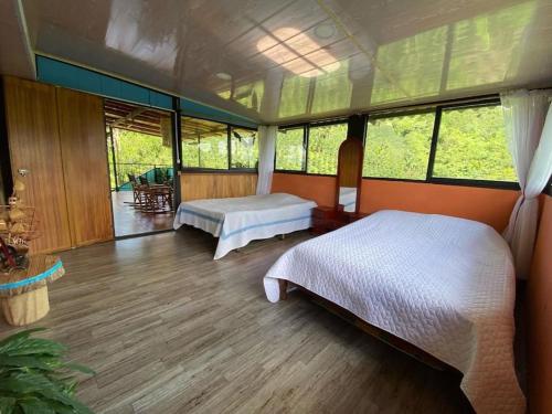 - une chambre avec 2 lits dans une pièce avec fenêtres dans l'établissement cabaña de guadua entre montañas, à Palestina