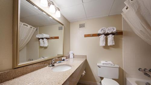 a bathroom with a sink and a toilet and a mirror at Best Western Lower South End in Charlotte