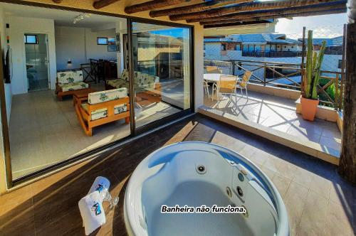 a bath tub in a room with a balcony at Cobertura Duplex 8 Pessoas Varanda Gourmet in Aquiraz