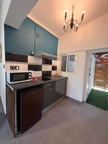 a kitchen with black cabinets and a stove top oven at Chez Permal in Saint-Pierre