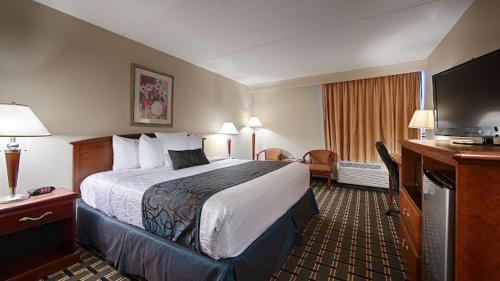 ein Hotelzimmer mit einem großen Bett und einem TV in der Unterkunft Best Western Lower South End in Charlotte