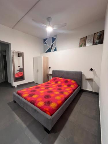 1 dormitorio con 1 cama grande con manta roja en Chez Permal en San Pedro