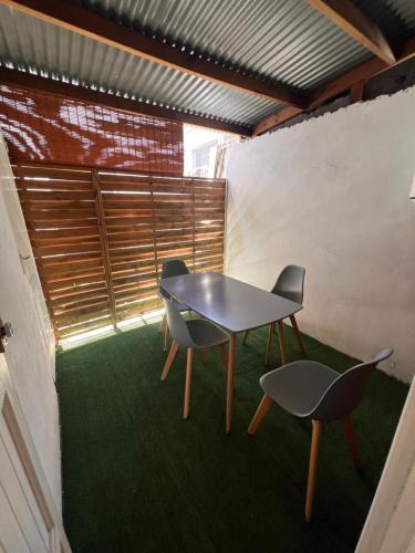 Una mesa y dos sillas en una habitación con césped en Chez Permal en San Pedro