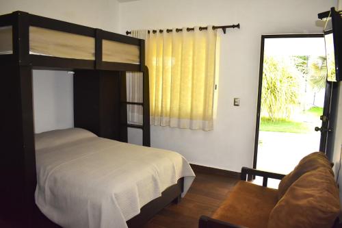 Schlafzimmer mit Etagenbett und Glasschiebetür in der Unterkunft Sunset in El Desengaño