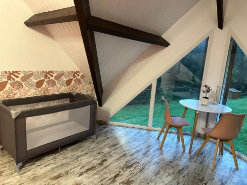 a room with a fireplace and a table and chairs at La Maison Verte in Clécy