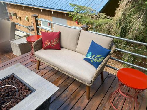 a couch on a deck with colorful pillows at Bell In The Woods B&B in Seward