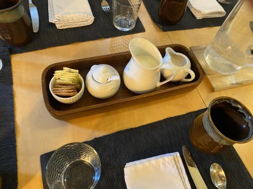 a table with a tray with tea cups and crackers at Bell In The Woods B&B in Seward