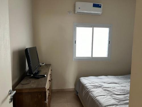 1 dormitorio con 1 cama y escritorio con TV en Ameghino 534 en San Juan