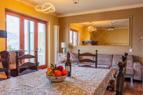 a table with a bowl of fruit and a bottle of wine at Villa Bianca by GardaDoma in Brenzone sul Garda