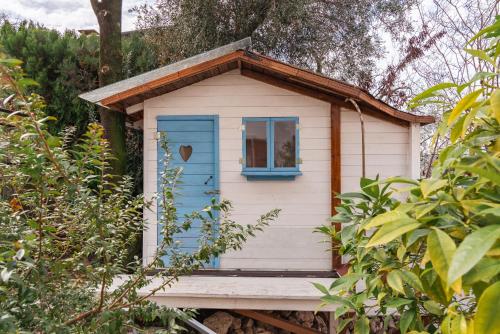 a small house with a blue door and a window at Villa Bianca by GardaDoma in Brenzone sul Garda