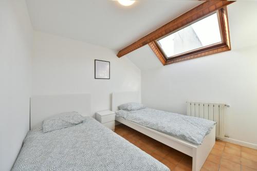 deux lits jumeaux dans une chambre avec fenêtre dans l'établissement Pleasant Appartment near Stade de France, à Saint-Denis
