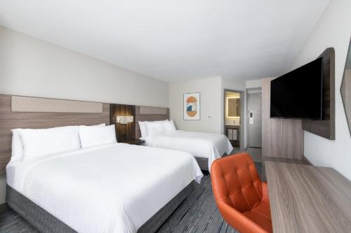 a hotel room with two beds and a flat screen tv at Holiday Inn Express Atlanta West - Theme Park Area by IHG in Lithia Springs