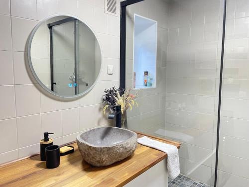 a bathroom with a stone sink and a mirror at Cocon chaleureux entièrement renové à 150m de le Seine in Saint-Mammès