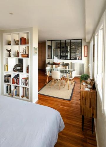 - une chambre avec un lit blanc et une salle à manger dans l'établissement Le cocon de Rueil-Malmaison, à Rueil-Malmaison