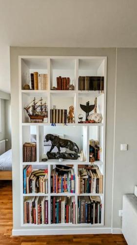 une étagère blanche remplie de livres dans une pièce dans l'établissement Le cocon de Rueil-Malmaison, à Rueil-Malmaison
