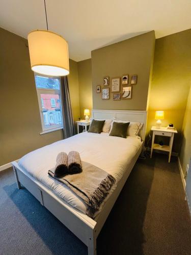 um quarto com uma grande cama branca e uma janela em Kings Bridge Townhouse em Belfast