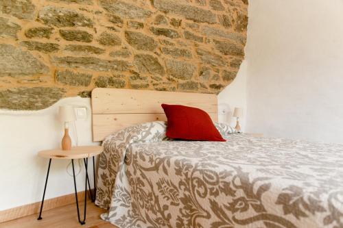 um quarto com uma cama e uma parede de tijolos em Casa do Lecer em La Teijeira