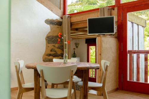 uma sala de jantar com mesa e cadeiras e uma televisão em Casa do Lecer em La Teijeira