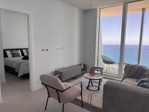 a living room with a bed and a view of the ocean at Ayia Napa Marina Exclusive Apartment in Ayia Napa