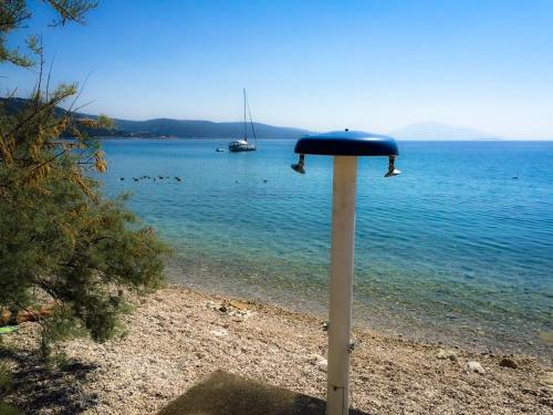 a blue object on the beach with a boat in the water at Apartments Tatjana in Martinšćica