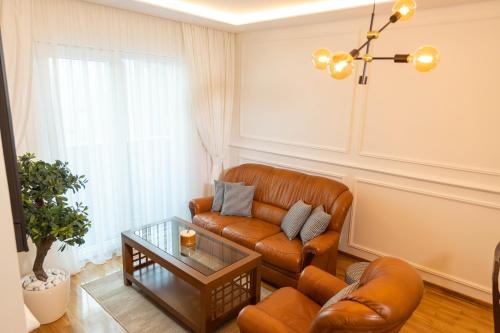 ein Wohnzimmer mit Ledersofa und einem Tisch in der Unterkunft MARNO Apartment in Budva