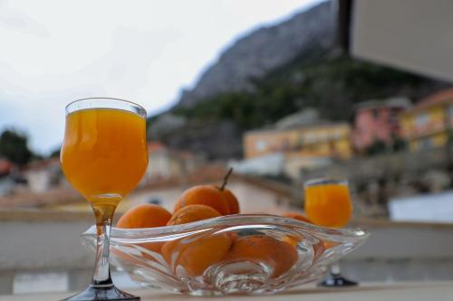 a glass bowl of oranges and a glass drink at Vila Taga Guesthouse in Krujë