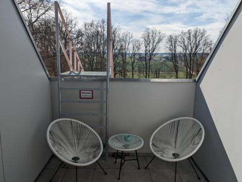 a balcony with two chairs and a large window at Suite 13 im Wald mit Balkon in Amberg