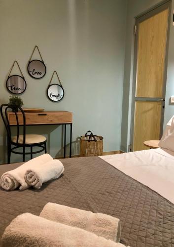 a bedroom with a bed and a desk with two mirrors at Marina rooms in Argostoli