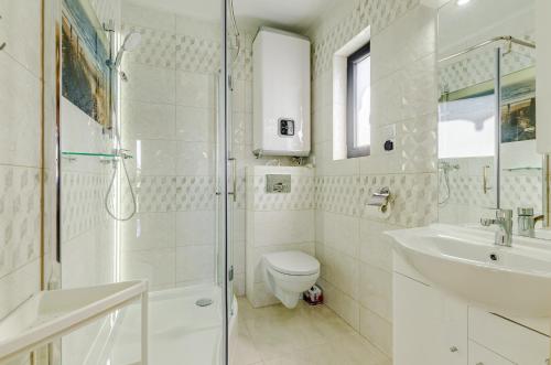 a bathroom with a toilet and a sink and a shower at Domki letniskowe Agata in Jantar