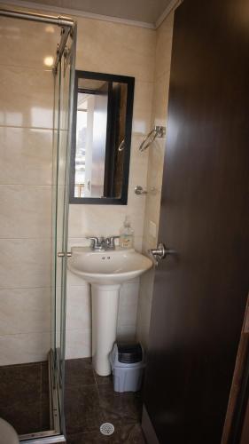 a bathroom with a sink and a mirror and a shower at Encantador cómodo y confortable. in Bogotá