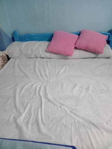 - un lit avec 2 oreillers roses dans l'établissement Beda, à Madīnat as Sādāt