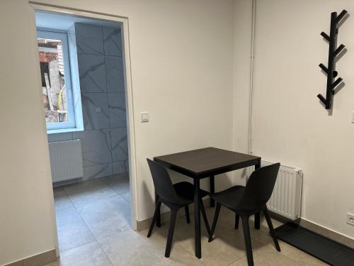 a black table and chairs in a room with a window at Guben Wohnungen in Guben