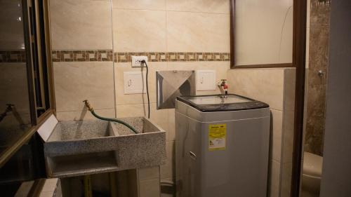 a bathroom with a sink and a washing machine at Encantador cómodo y confortable. in Bogotá