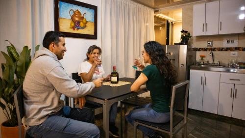 a group of people sitting around a table drinking wine at Encantador cómodo y confortable. in Bogotá