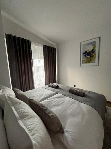 a bedroom with a large white bed in front of a window at Apartman Orchid in Plitvička Jezera