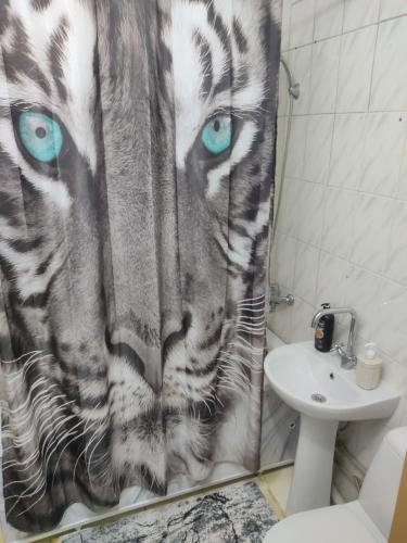 a bathroom with a tiger shower curtain with blue eyes at Просторные 2-х комнатные апартаменты на 5 спальных мест in Ustʼ-Kamenogorsk