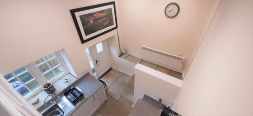 an overhead view of a living room with a clock on the wall at LetAway - 16th Century Cottage in Richmond