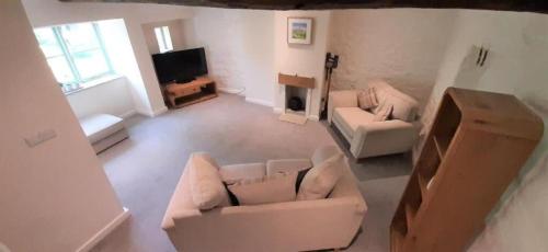 a living room with two couches and a tv at LetAway - The Curtain (13th Century Cottage) in Richmond